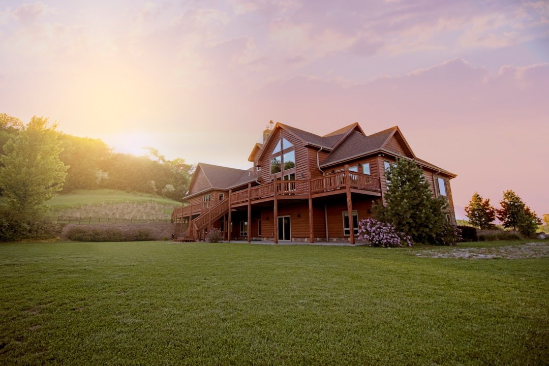 brown wooden house with green grass field